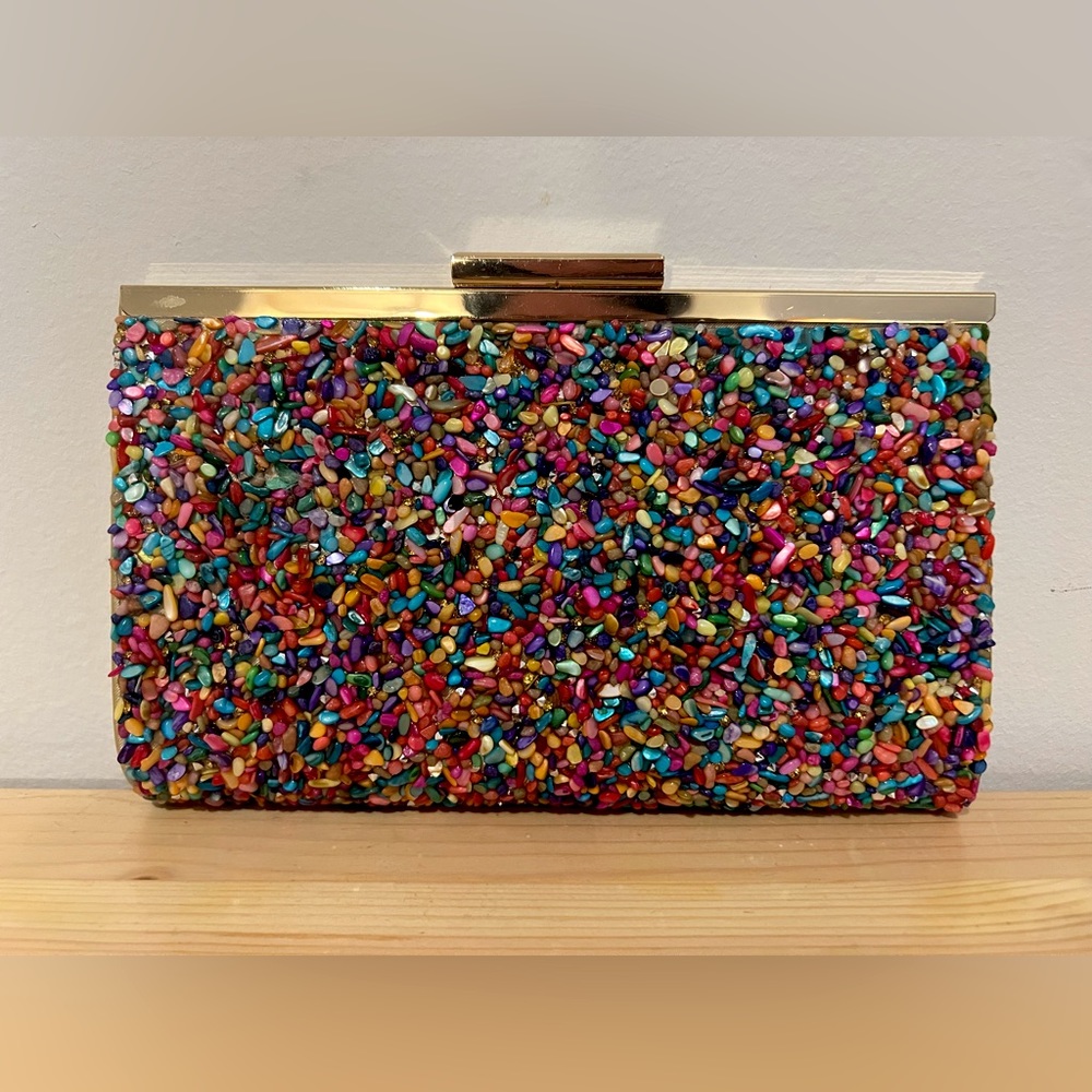 Multicolor clutch with detachable gold chain.